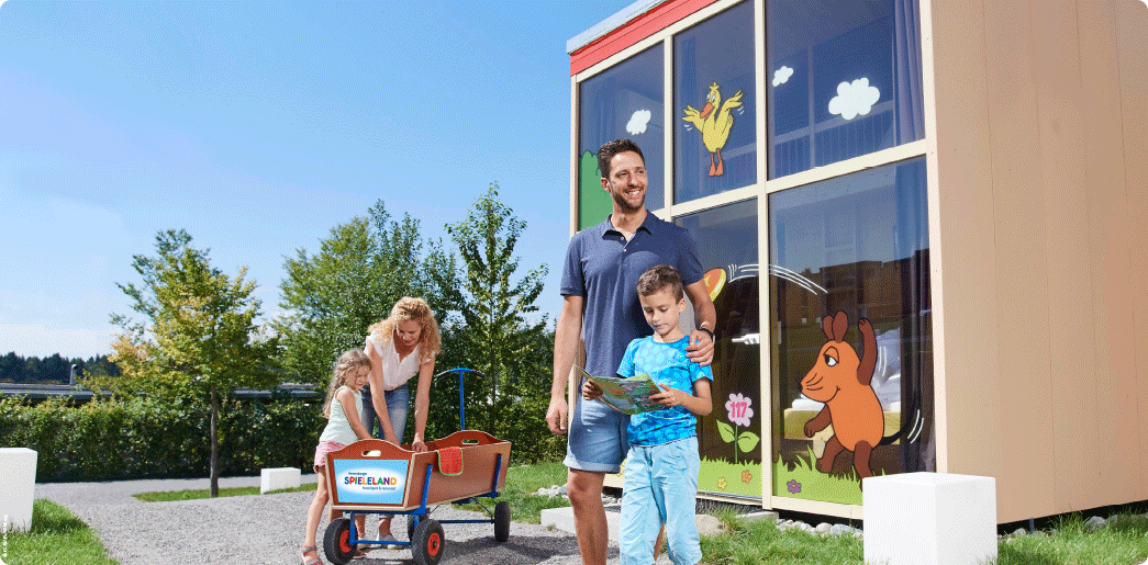 Ferienhaus_Bild_ Familie im Feriendorf vor Ferienhaus